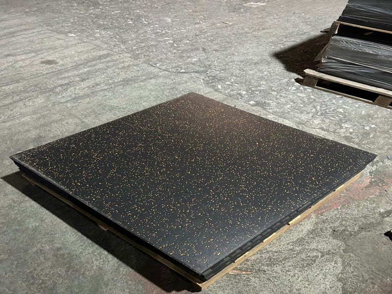 A detailed macro shot of a black rubber tile showing the integrated colorful EPDM flecks.